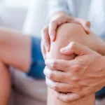 Hände umschlingen ein Knie