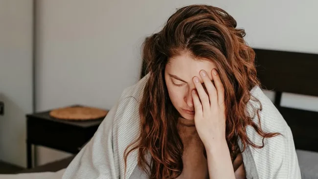 Migräne - eine Frau mit Kopfschmerzen